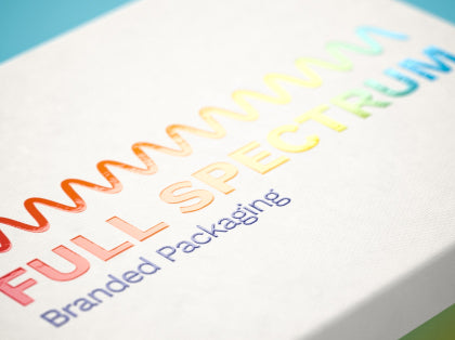 Side angle of the surface of printed white box showcasing spot UV gloss in a rainbow color.